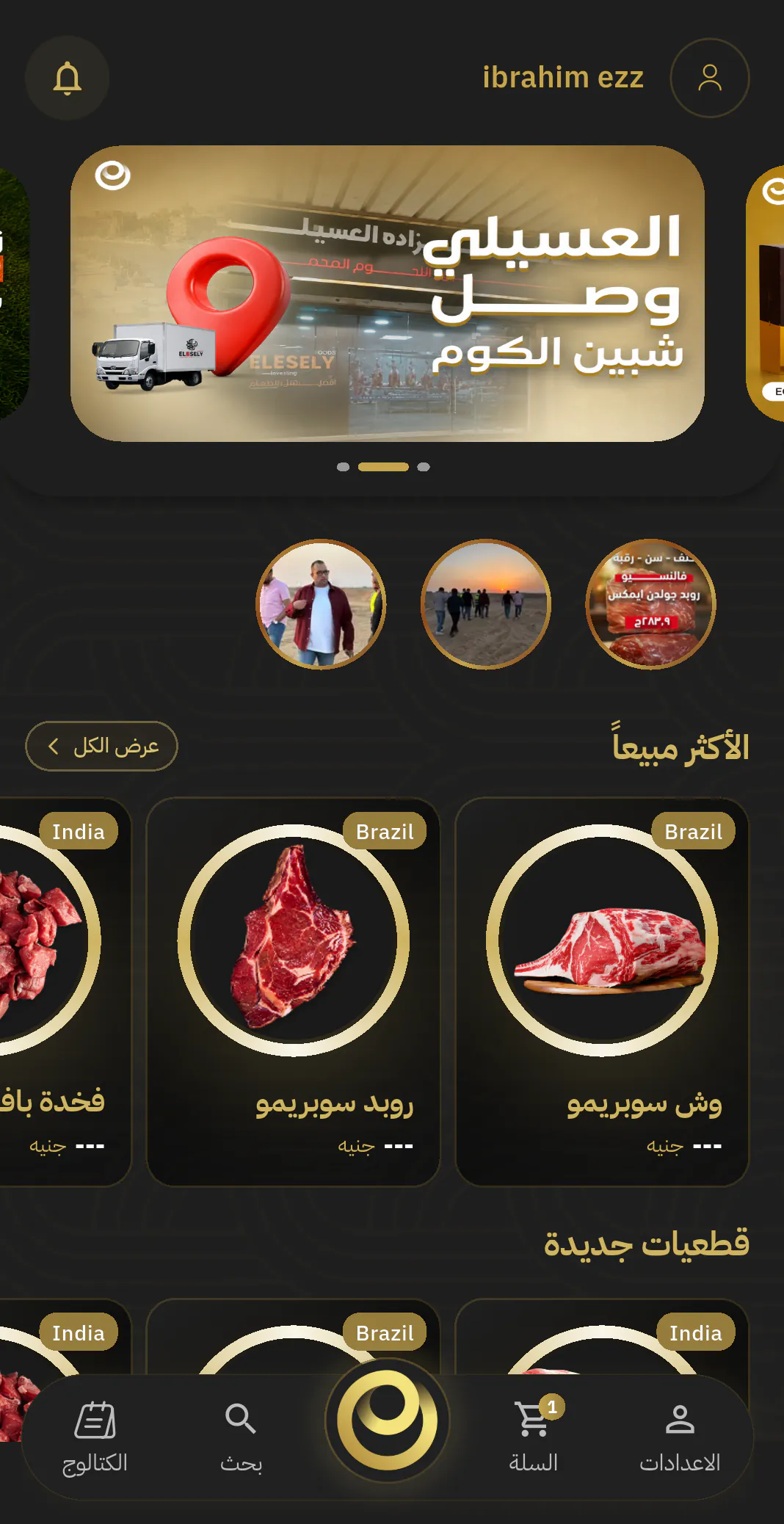 تطبيق مجموعة العسيلي على الهاتف: الشاشة الرئيسية، وفيها لافتة المجموعة، وبطاقات الاكثر مبيعا من قطعيات اللحوم في اطارات ذهبية، وتبويبات الكتالوج والبحث والسلة.